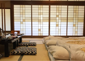 3 futons laying on the tatami floors of a ryokan room