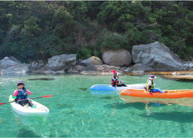 A group of three kayaks floating on the pristine waters of Takeno beach