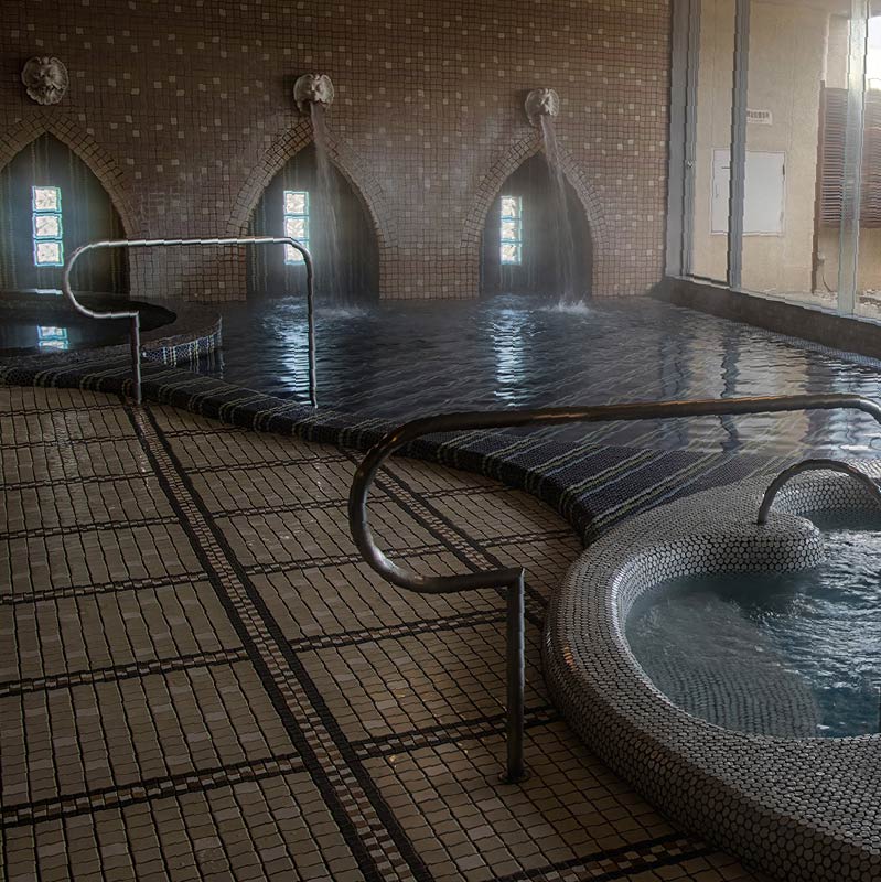 The modern tiled interior baths of Satonoyu Onsen at daytime. The decoration and ornamentation of the baths makes it seem almost gothic