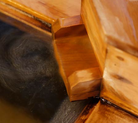 Hot water flows out a wooden funnel into the pool at the corner of one of Yanagiyu Onsen's interior baths