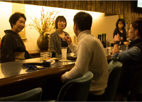 The 'mama-san' and other bartenders talking to the guests of the Snack Bar