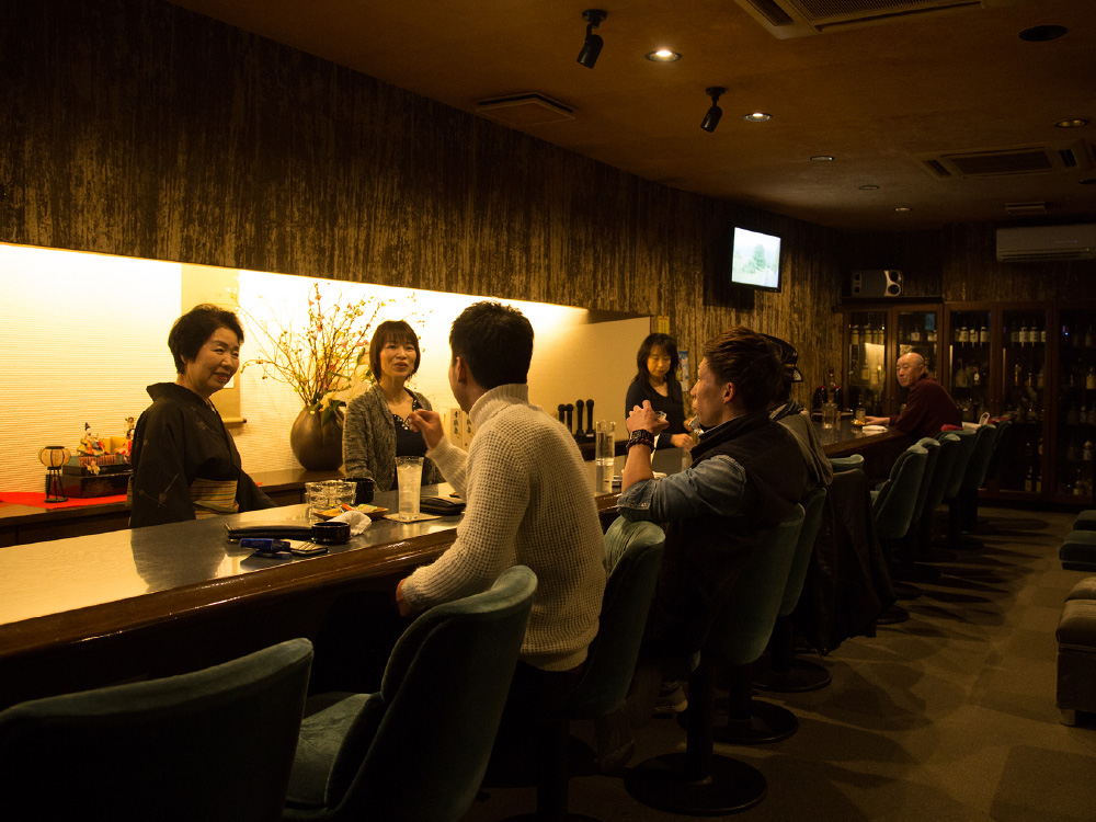 The 'mama-san' and other bartenders talking to the guests of the Snack Bar