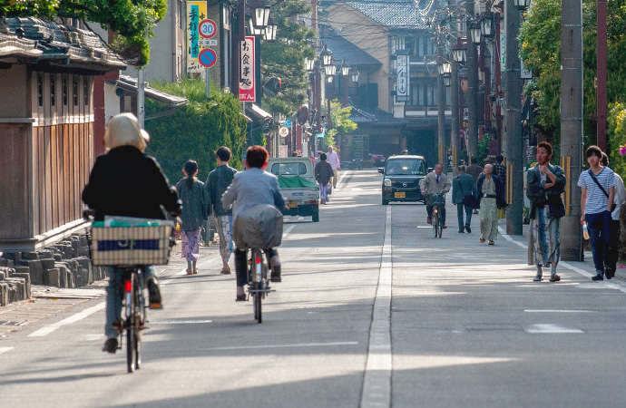 Various townspeople hustling and bustling on one of Kinosaki Onsen's many streets