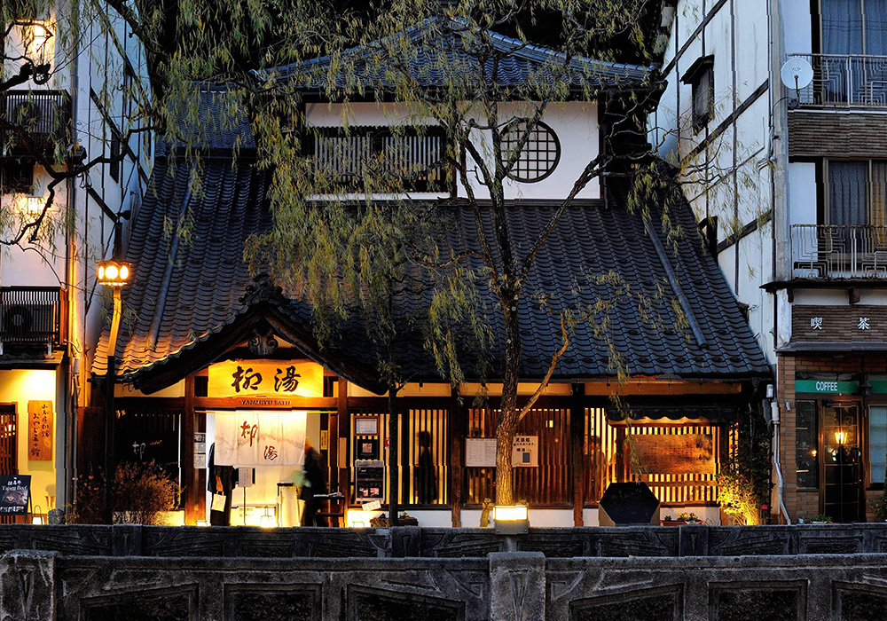 Yanagiyu Onsen's exterior at twilight. It's exterior lanterns give off a strong atmosphere