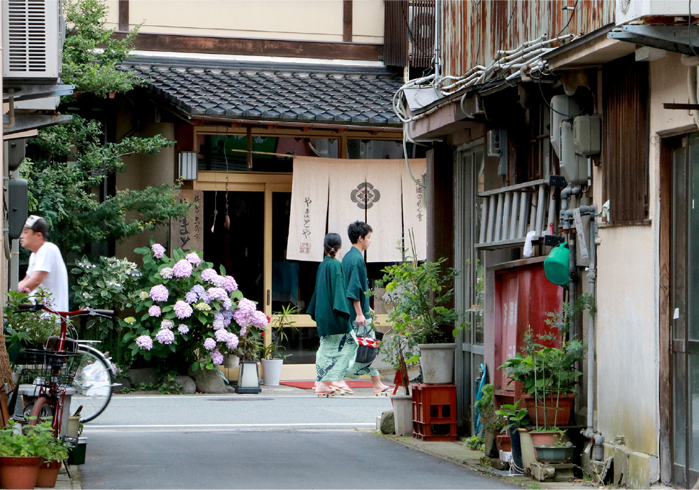 The back alley of Kinosaki. Traditional wooden styled buildings and blooming flowers