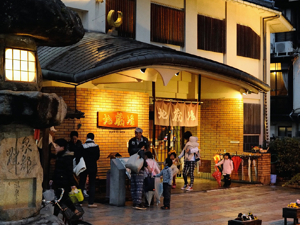 The exterior of Jizoyu Onsen, with many people waiting around outside