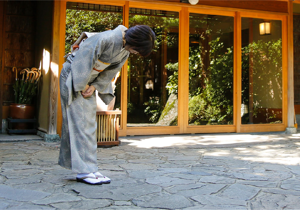 Ryokan staff bowing in farewell to guests as they leave